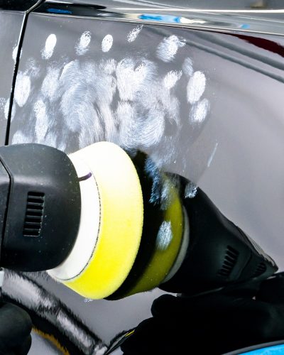 Buffing and polishing car. Car detailing. Man holds a polisher in the hand and polishes the car. Tools for polishing